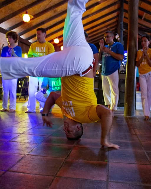 Capoeirista se equilibra sobre as mãos durante o jogo
