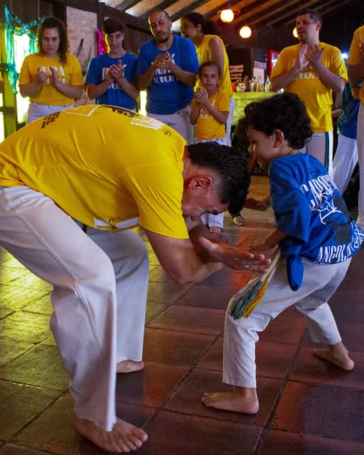 Adulto e criança do Ingá se cumprimentam antes de jogar capoeira